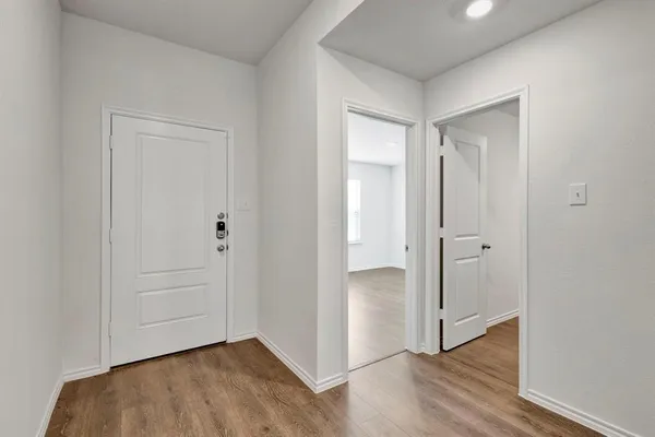 an empty room with wooden floor and closet area