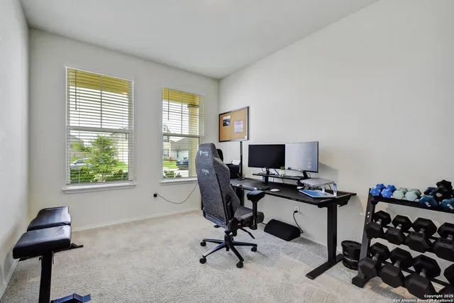 a view of a workspace with furniture and a window