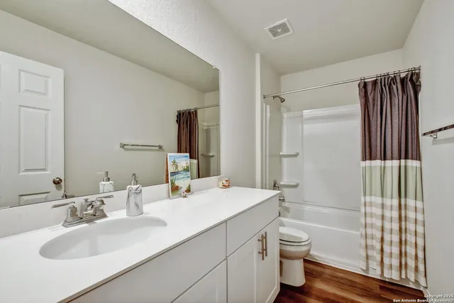 a bathroom with a granite countertop sink toilet and shower