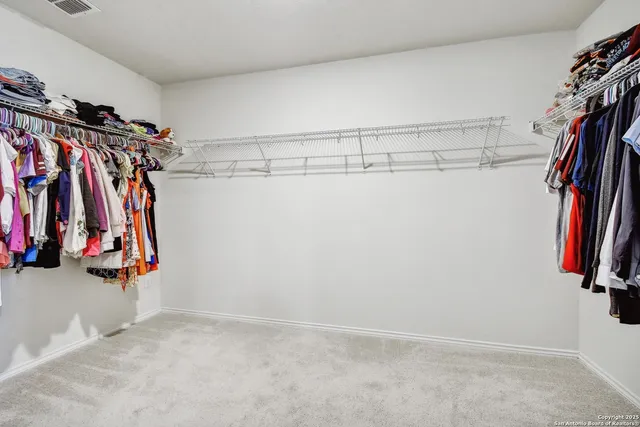 a view of walk in closet with clothes