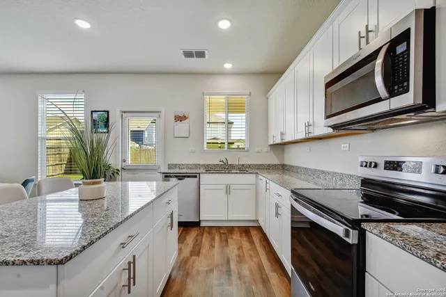 a kitchen with stainless steel appliances granite countertop a sink and stove top oven