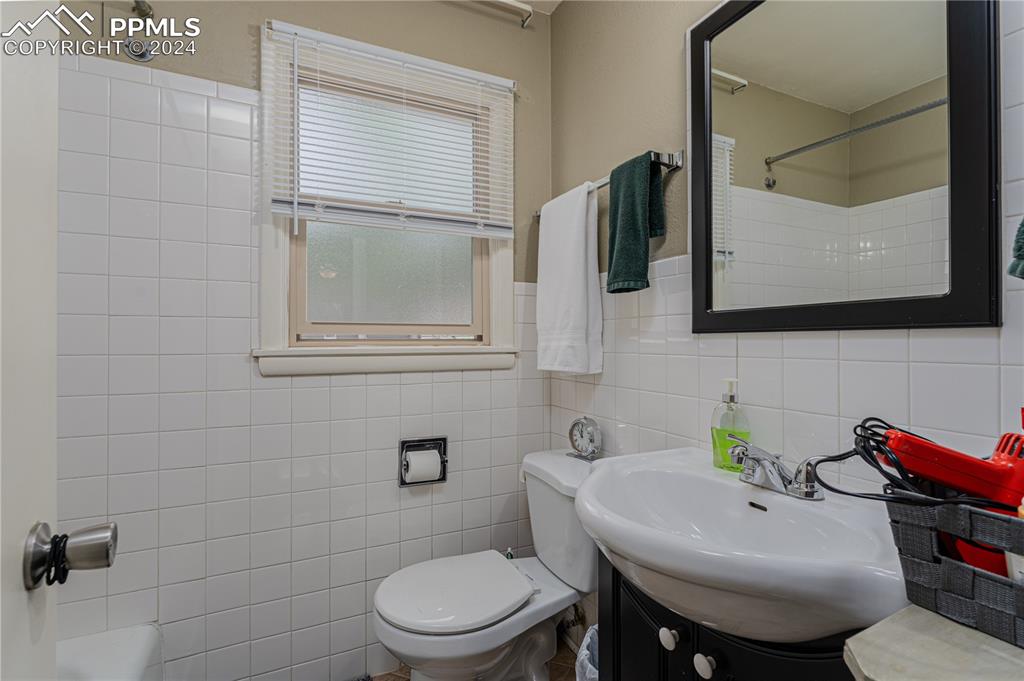 1002 Alexander Road Colorado Springs, CO 80909 - Photo 23 of 28 a bathroom with a sink mirror and toilet