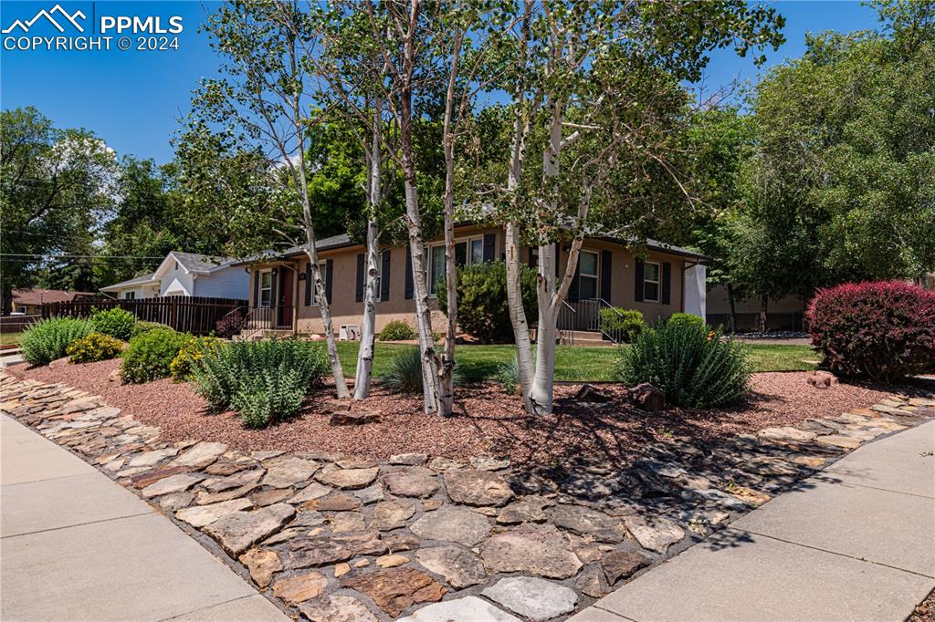 1002 Alexander Road Colorado Springs, CO 80909 - Photo 7 of 28 a front view of a house with a garden