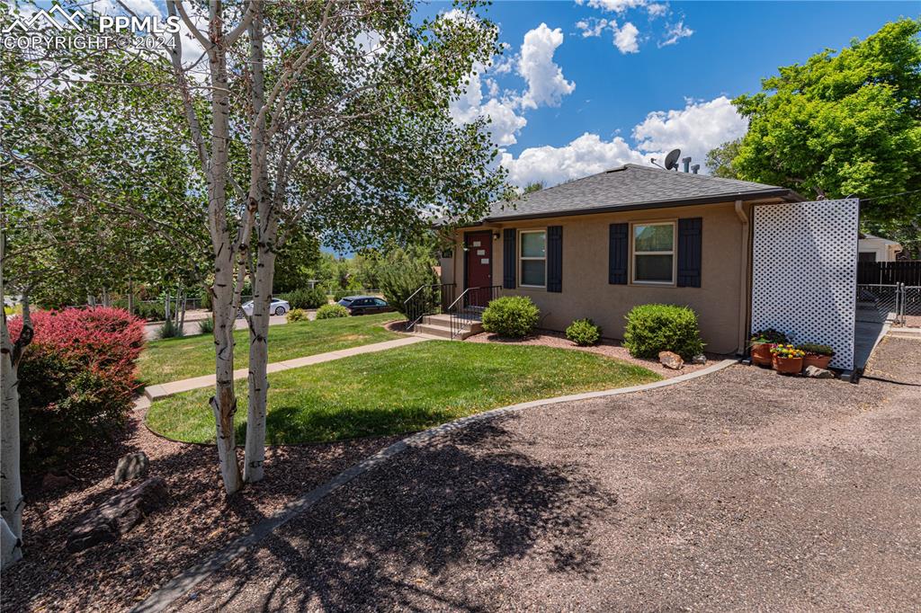 1002 Alexander Road Colorado Springs, CO 80909 - Photo 8 of 28 a front view of a house with garden