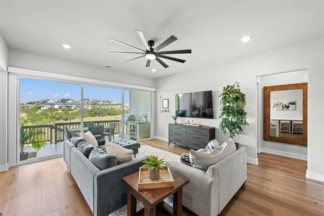a living room with furniture a flat screen tv and a large window