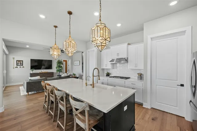 a large kitchen with kitchen island a sink dining table and chairs