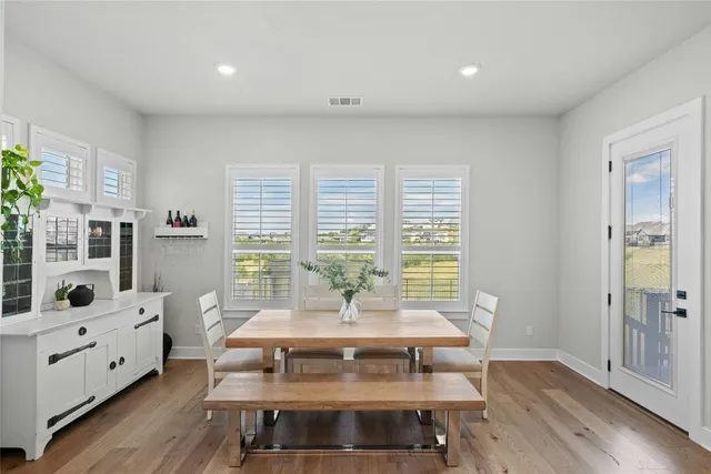 a view of a dining room with furniture a chandelier and wooden floor