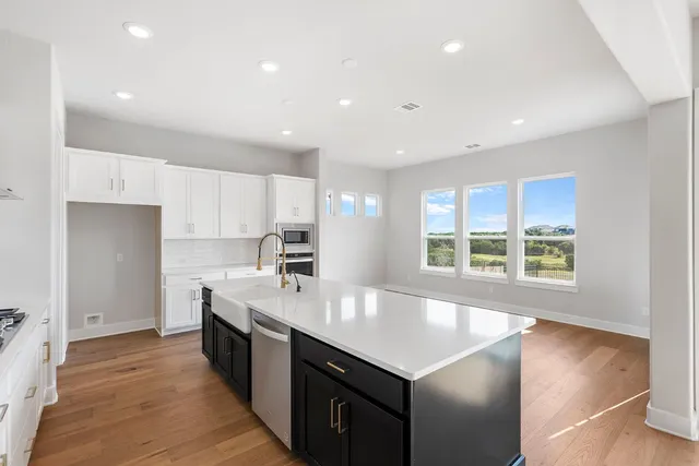 a view of an empty room with wooden floor and stairs