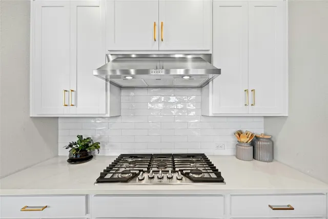 a large kitchen with stainless steel appliances a stove center island a oven a counter space and cabinets