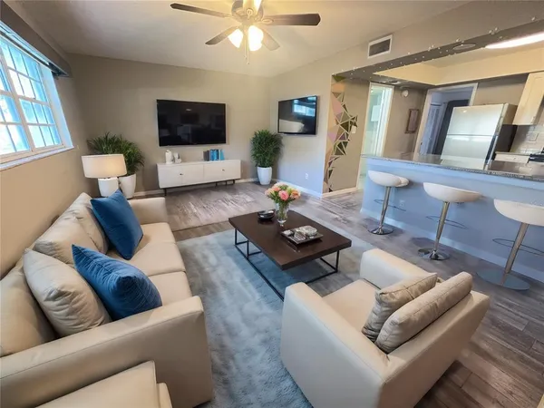 a living room with furniture a flat screen tv and a large window