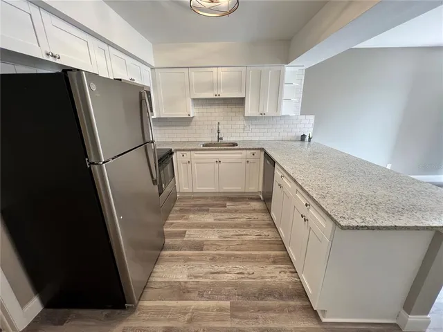 a kitchen with granite countertop a refrigerator and a sink