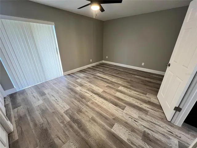 a view of a room with wooden floor and fan