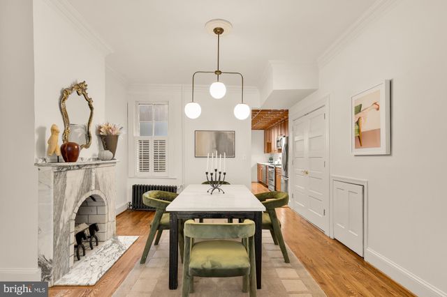 a dining room with wooden floor a chandelier a wooden table and chairs