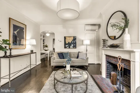 a living room with furniture a mirror and a fireplace