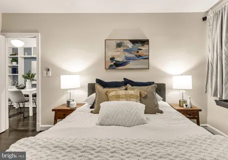 a bedroom with a large bed and a chandelier