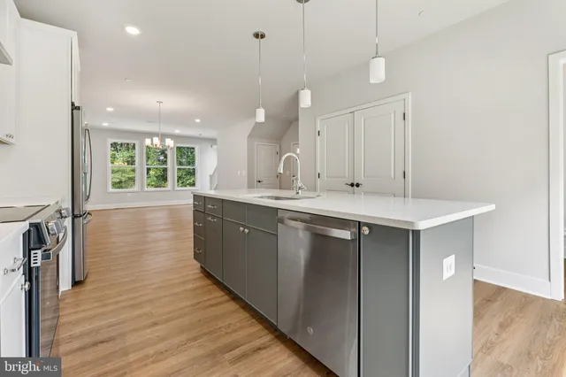 a kitchen with kitchen island granite countertop a sink window and wooden floor