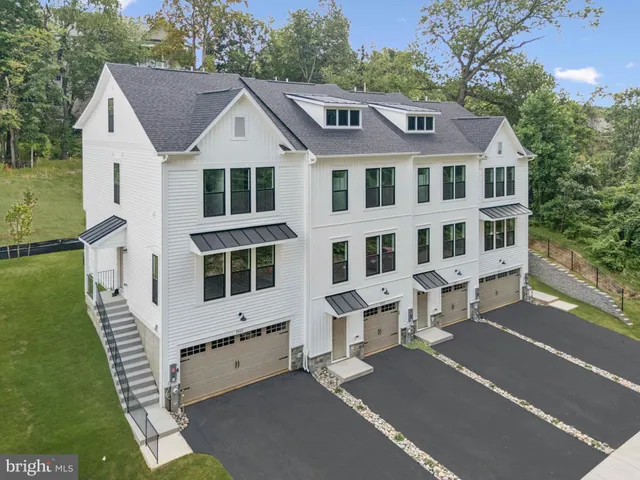 a view of residential houses with yard and car parked