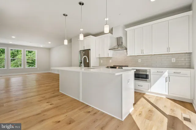 a kitchen with kitchen island a stove a sink a center island and a window