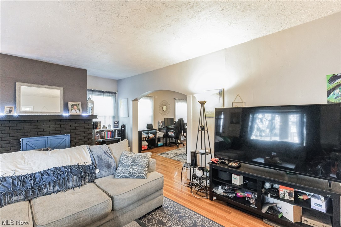 5880 State Road Cleveland, OH 44134 - Photo 6 of 21 Living room featuring light hardwood / wood-style floors, a fireplace, and a textured ceiling