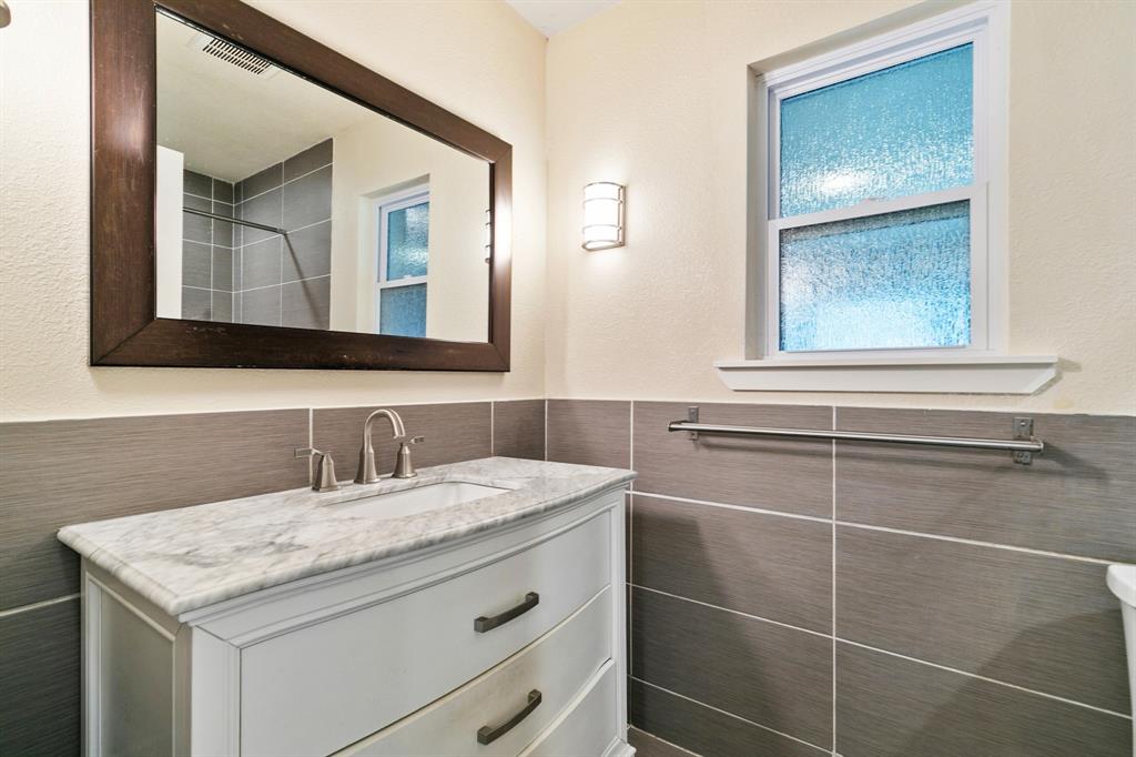 909 North Dove Road Grapevine, TX 76051 - Photo 18 of 30 Primary Bathroom vanity featuring a light marble-finish countertop, undermount sink, and brushed nickel faucet