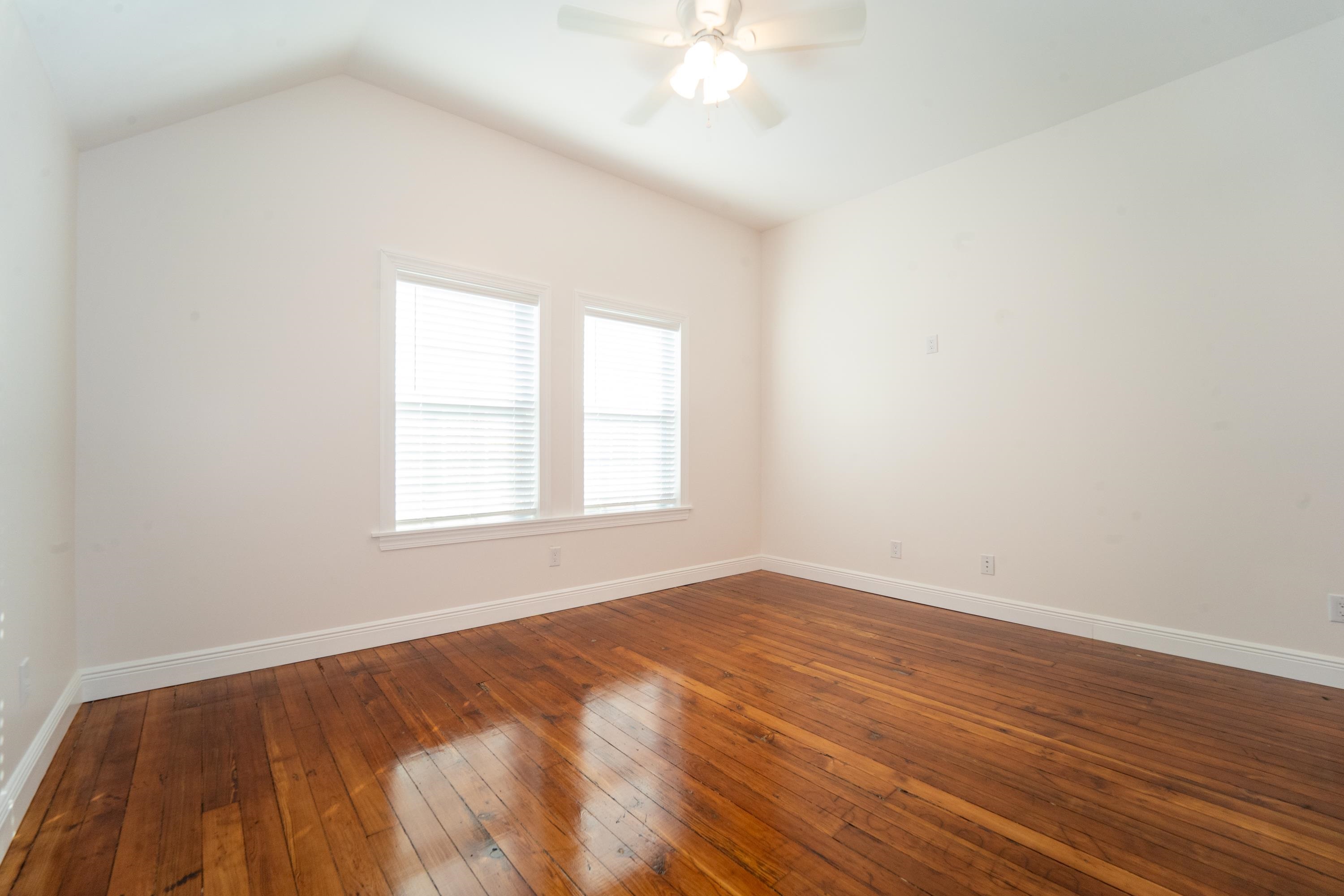 11 Aviles Street, Unit 2D St. Augustine, FL 32084 - Photo 12 of 24 an empty room with wooden floor and windows