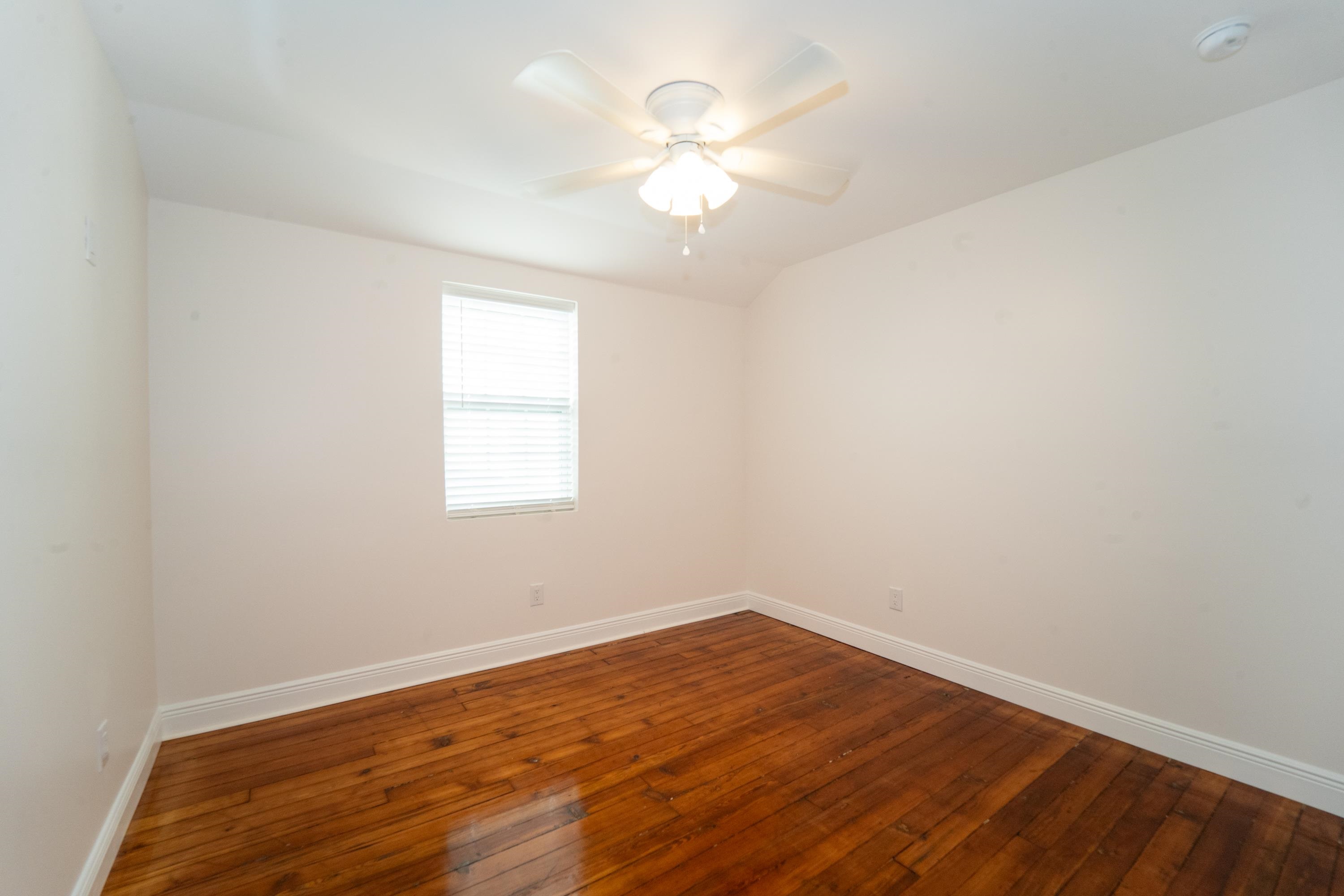 11 Aviles Street, Unit 2D St. Augustine, FL 32084 - Photo 15 of 24 an empty room with wooden floor and windows