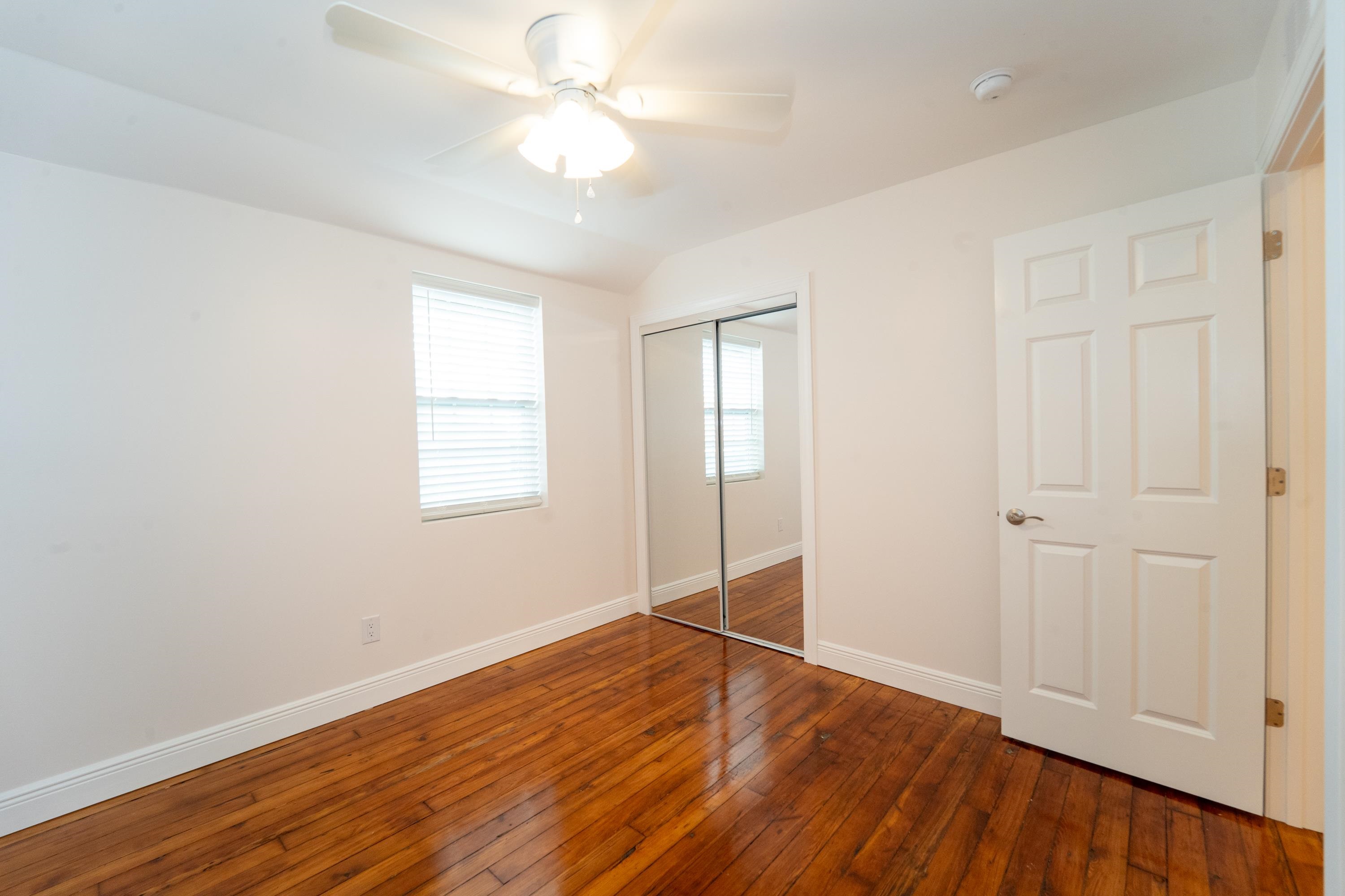 11 Aviles Street, Unit 2D St. Augustine, FL 32084 - Photo 17 of 24 an empty room with wooden floor and windows