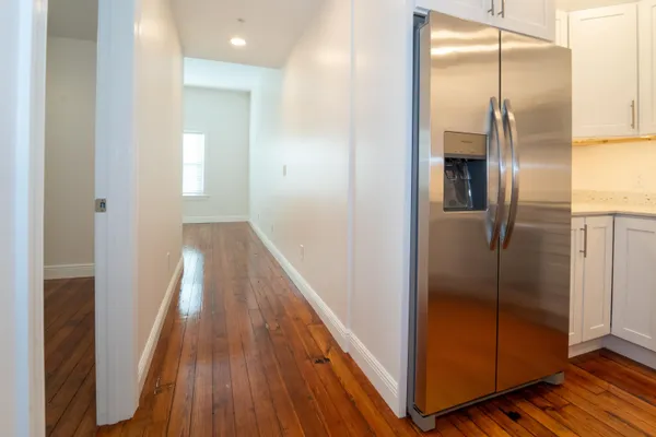 a kitchen with stainless steel appliances granite countertop a refrigerator a stove and a microwave with wooden floor