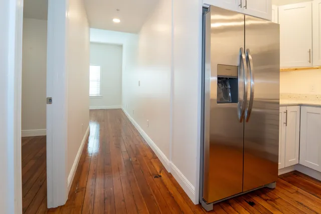 a kitchen with stainless steel appliances granite countertop a refrigerator a stove and a microwave with wooden floor