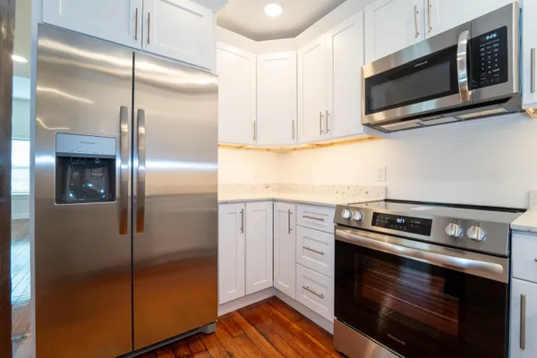a kitchen with granite countertop white cabinets stainless steel appliances and sink