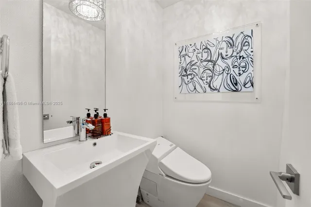 a bathroom with a sink mirror and toilet