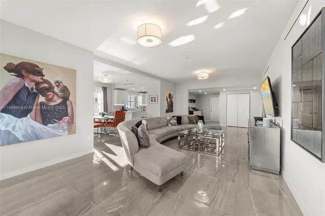 a living room with furniture and a view of kitchen