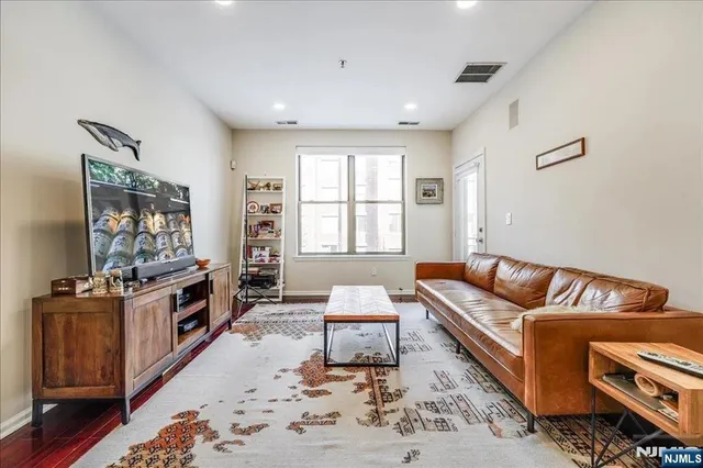 a living room with furniture a flat screen tv and a table