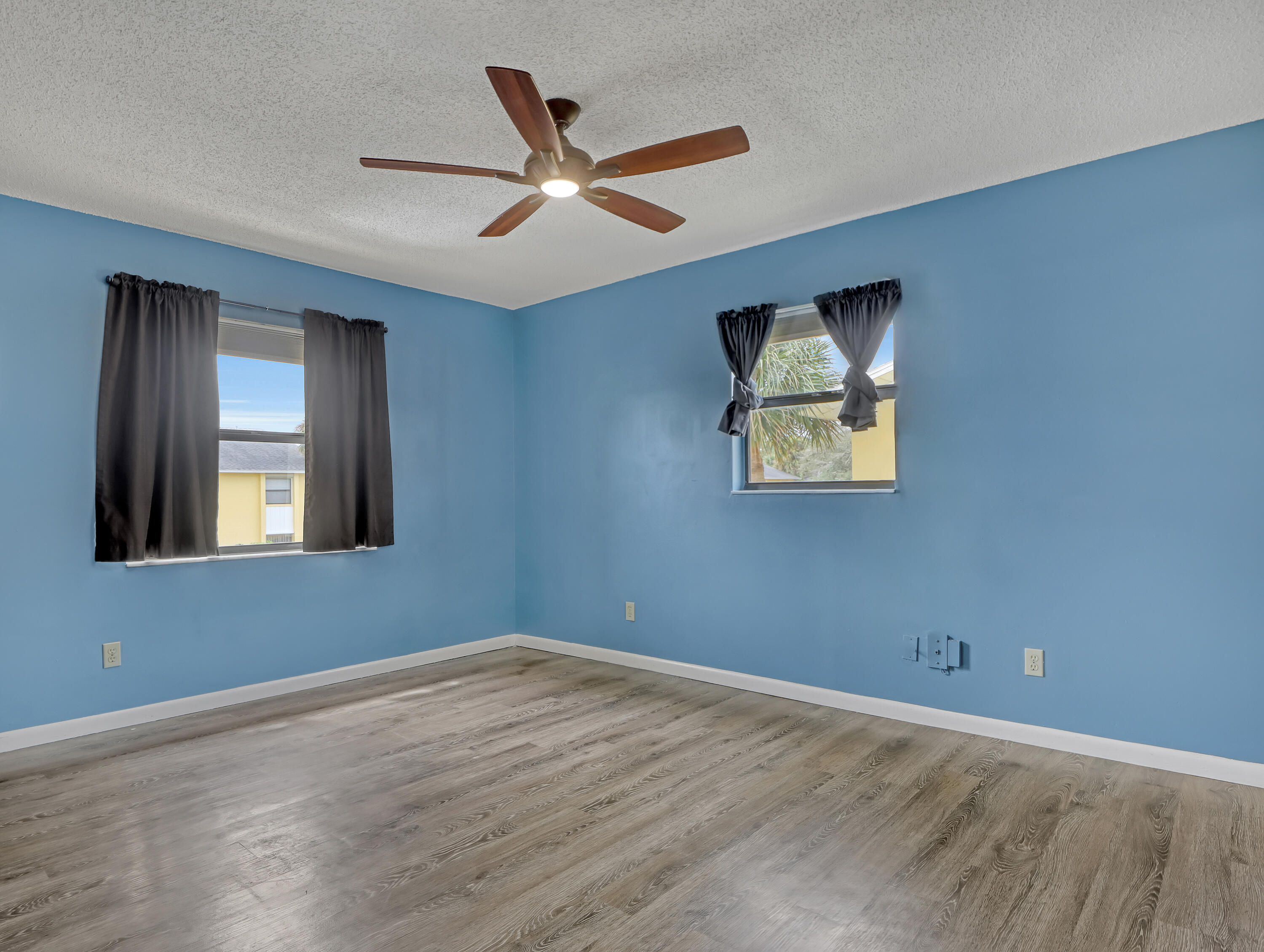 592 North Wickham Road, Unit 18 Melbourne, FL 32935 - Photo 17 of 29 a view of an empty room with window and wooden floor