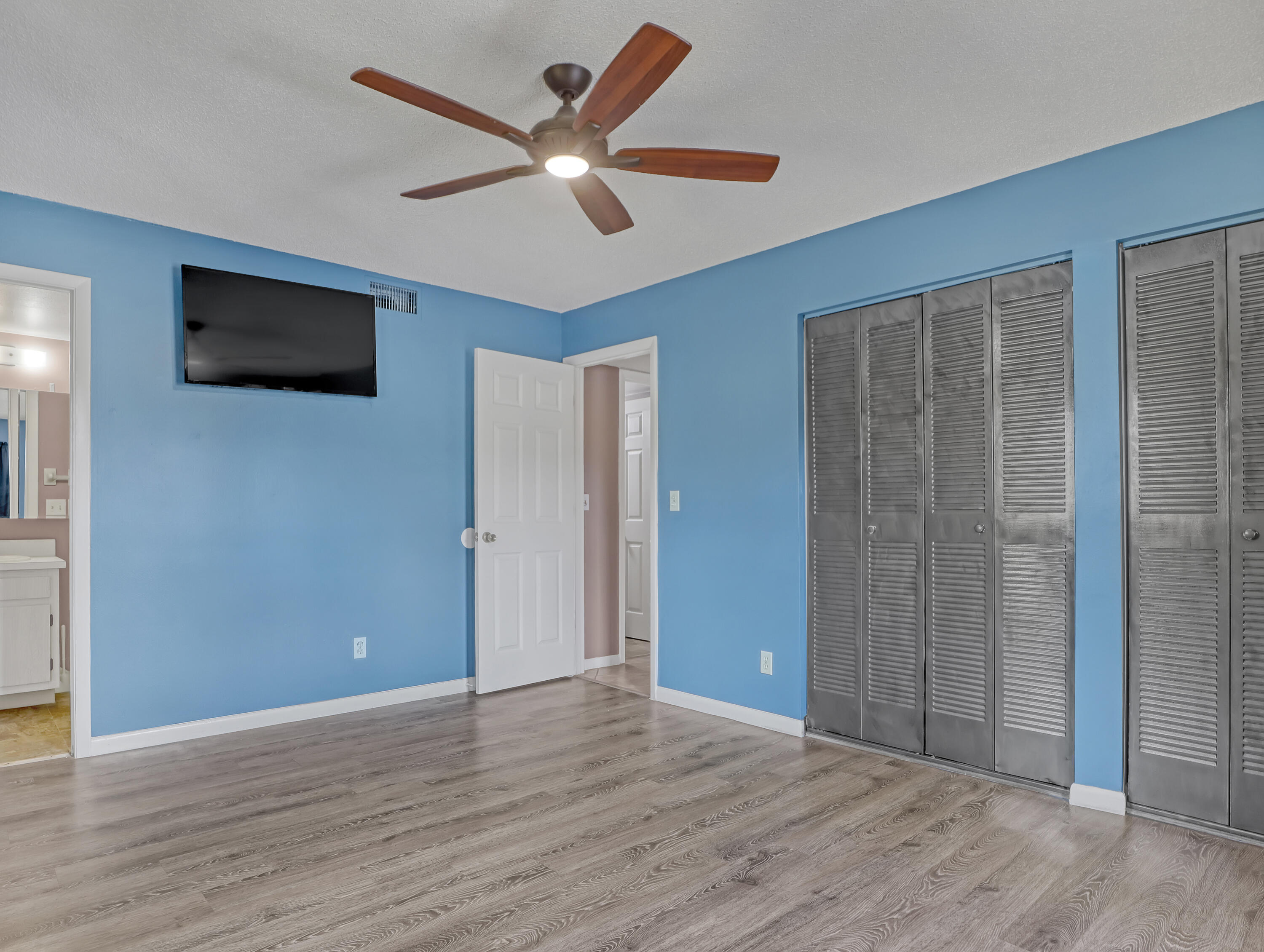 592 North Wickham Road, Unit 18 Melbourne, FL 32935 - Photo 18 of 29 an empty room with wooden floor fan and windows