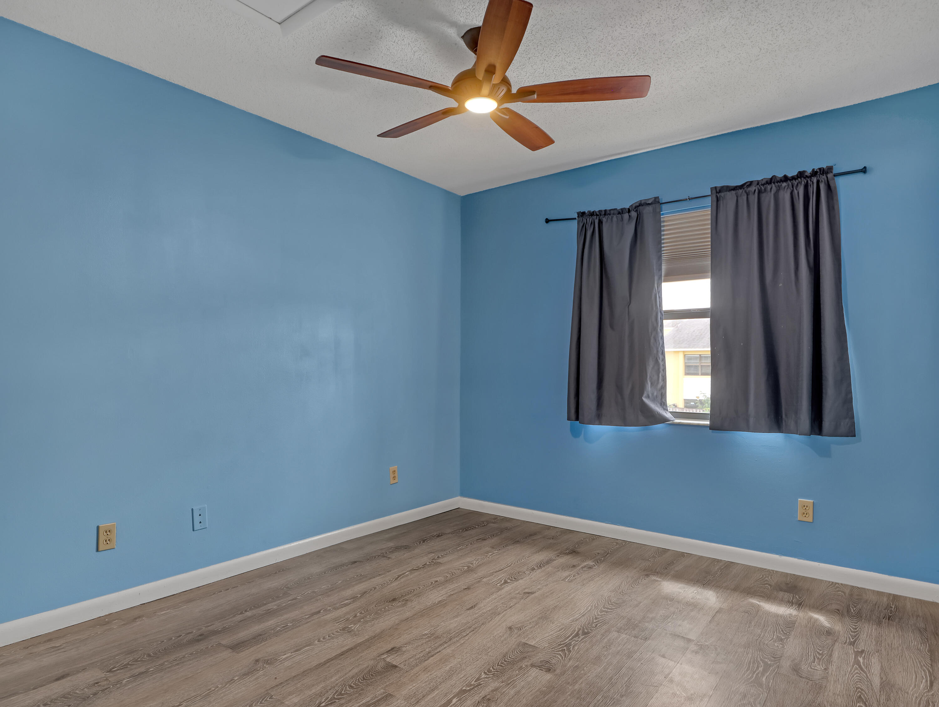 592 North Wickham Road, Unit 18 Melbourne, FL 32935 - Photo 20 of 29 a view of an empty room with window and chandelier fan
