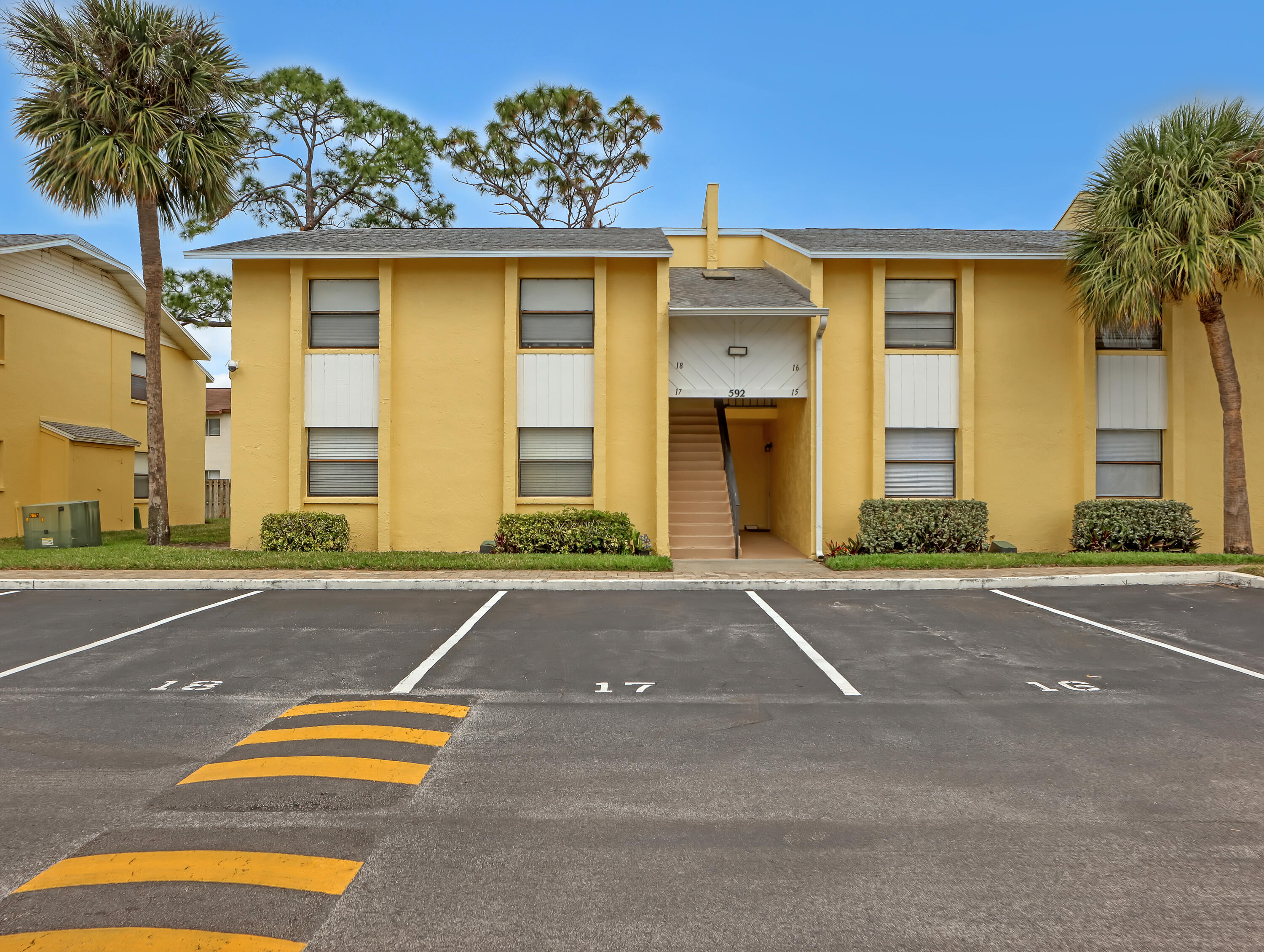 592 North Wickham Road, Unit 18 Melbourne, FL 32935 - Photo 3 of 29 a front view of a house with a yard and garage