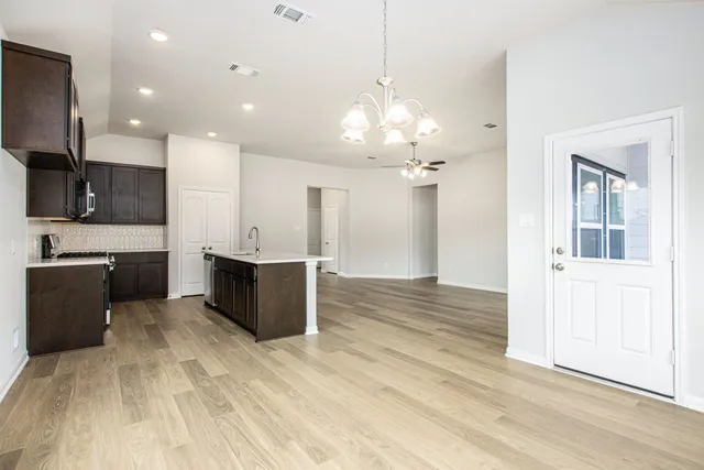 a large kitchen with kitchen island a sink stainless steel appliances and cabinets