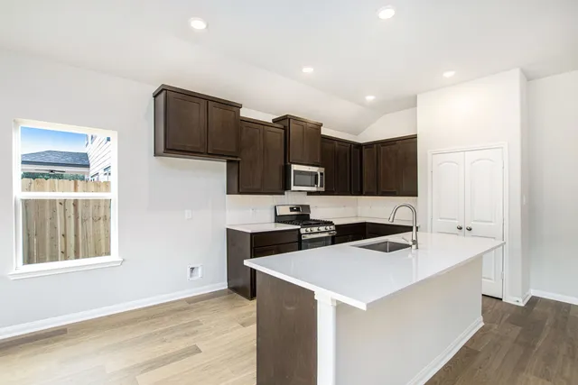a kitchen that has a sink a stove and a refrigerator