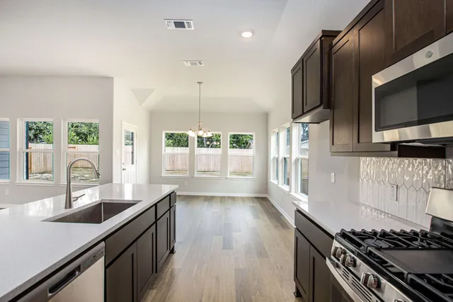 a kitchen with stainless steel appliances a sink stove and oven