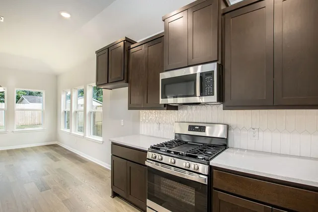 a kitchen with granite countertop a stove and a microwave
