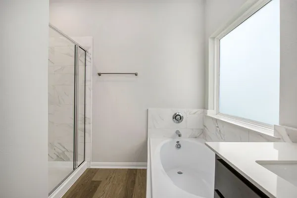 a bathroom with a tub sink and mirror
