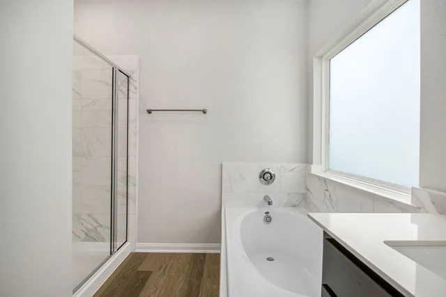 a bathroom with a tub sink and mirror