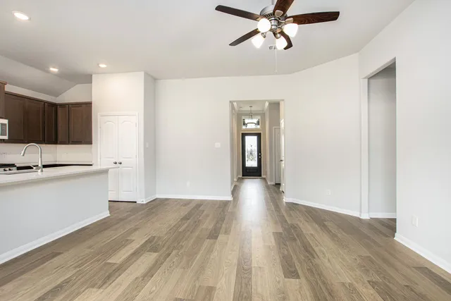 a view of a kitchen with a sink and dishwasher a refrigerator with wooden floor