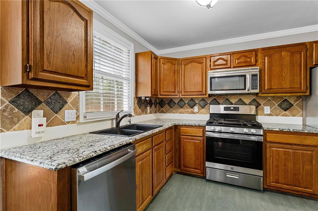 1996 Morning Walk Northwest Acworth, GA 30102 - Photo 8 of 22 a kitchen with stainless steel appliances granite countertop wooden cabinets stove and a granite counter top