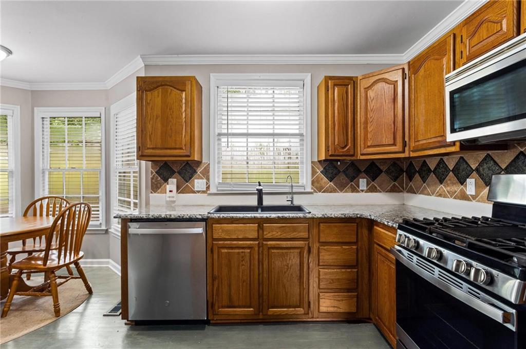 1996 Morning Walk Northwest Acworth, GA 30102 - Photo 10 of 22 a kitchen with stainless steel appliances granite countertop a stove a sink dishwasher a microwave oven with granite countertops and cabinets