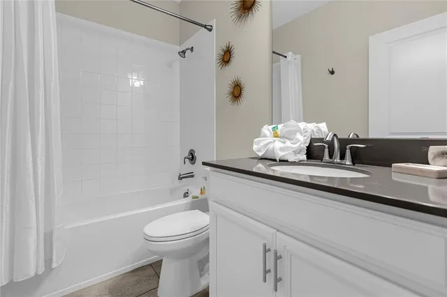 a bathroom with a granite countertop sink a toilet a shower and a mirror