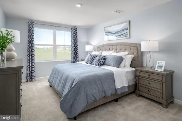 a spacious bedroom with a bed and window