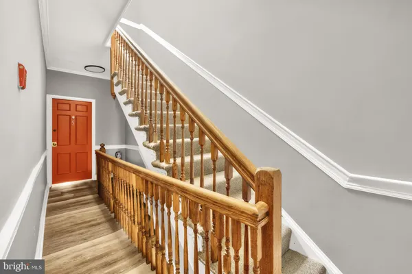 a view of staircase with wooden floor and white walls
