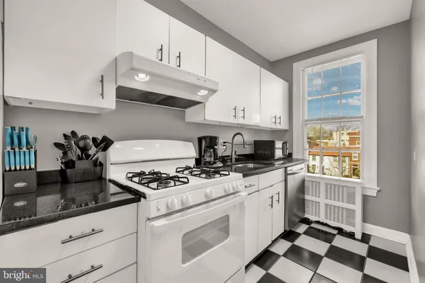 a kitchen with granite countertop cabinets and window